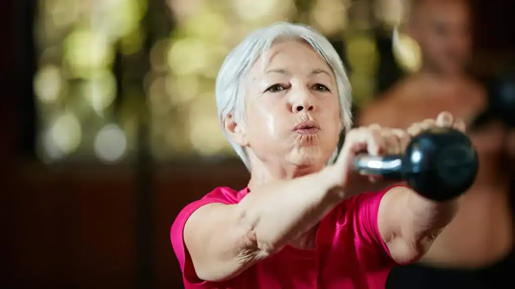 Older woman doing weight training Wolverhampton to help her strength and longevity 