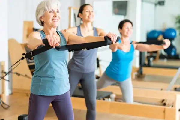 Toning Arms After 60: Empowering Womens Fitness Through Effective Weight Training 2 older woman doing weight training Wolverhampton and resistance in the gym to tone upper arms
