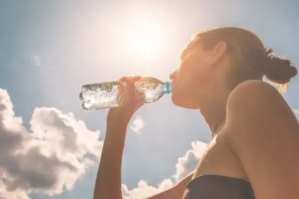Hydration: The Secret Ingredient for a Toned Stomach and Enhanced Fitness 3 Image of woman drinking water to hydrate Wolverhampton after run.
