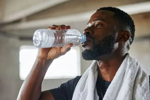 Hydration: The Secret Ingredient for a Toned Stomach and Enhanced Fitness 1 Image of man drinking water to improve hydration Wolverhampton after work out.
